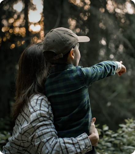 Child pointing into woodland at Mossend Farm